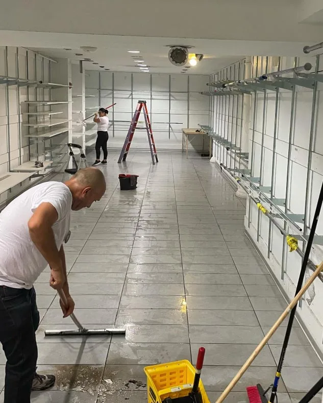 Crew squeegeeing water from a store floor