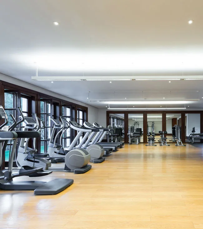 Clean gym floor with rows of cardio machines